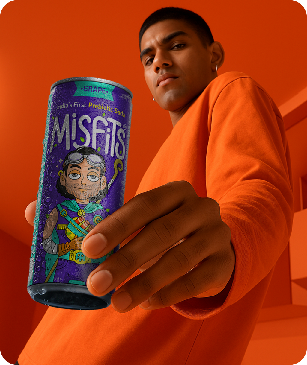 Person holding a can of Misfits soda against an orange background