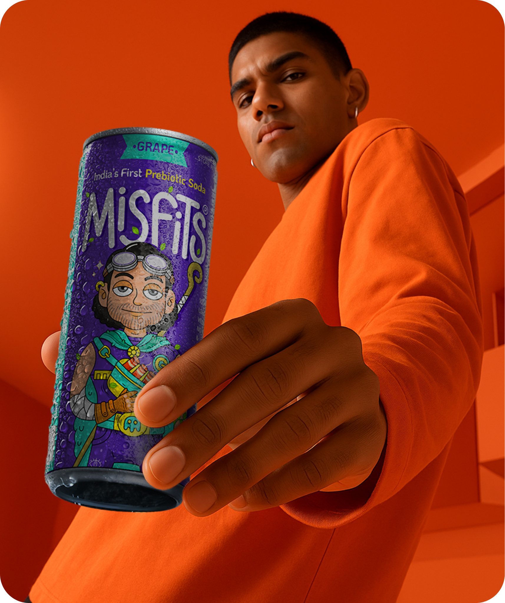 Person holding a can of Misfits soda against an orange background