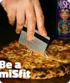 Person holding a can of Misfits soda against an orange background